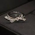 Detail of silver bow ring with shimmering cubic zirconia and inner blue sapphire accent - Bowknot Ring