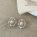 Detail van onregelmatige zilveren lava metalen oorbellen met witte hangende parel - Zilver