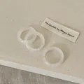 Detailopname van drie minimalistische harsringen op een getextureerde linnen ondergrond - Bergkristal