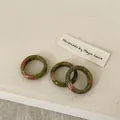Detailed macro view of three unakite natural stone rings on rustic linen background - Unakite