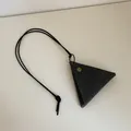 Macro view of triangular dark gray leather glasses pouch with vintage brass button snap - Black