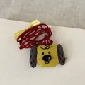 Détail du pendentif chiot en tissu jaune fait main avec cordon en velours rouge - Chien Jaune