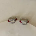 Detail view of horseshoe earrings with micro-set zircon and red enamel finish - Red