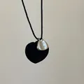 Macro detail of heart pendant with 'TAKE IT EASY' engraved silver plate on black twisted rope - Black Velvet Heart Necklace