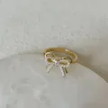 Macro detail of golden butterfly ring with white pearls and central square zircon - Artificial Pearl Bow Zirconia Style 9 Ring