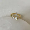 Detail of adjustable gold ring with white enamel bow and sparkling zircon accents - Mother of Pearl Bow Zirconia Style (Style 4 Ring)