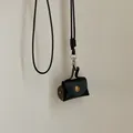 Close-up of mini black leather pendant pouch with metal snap button and long lanyard - Black