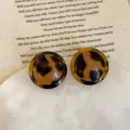 Close-up of vintage leopard print resin earrings on a white marble display tray - 925 Silver Earring Post / Style 4 Amber Translucent Border Leopard