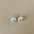 Detail of French vintage irregular pearl earrings with hammered texture on beige fabric - Hemispherical Pearl / Medium (12mm)
