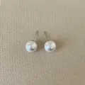 Close-up of polished 10mm white pearl stud earrings with 925 silver needles - Round Pearl / Small (10mm)
