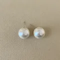 Detail of irregular hammer-textured cream pearl earrings with silver posts for women - Round Pearl / Large (14mm)