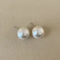Close-up of pearl white stud earrings with hammered texture on beige fabric - Round Pearl / Extra Large (16mm)