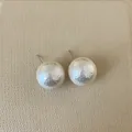 Macro shot of French vintage irregular pearl earrings with hammered metallic texture - Round Pearl / XX-Large (18mm)