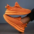 Detail view of bright orange breathable mesh running shoes with durable rubber soles - Orange