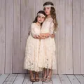 Detalle de vestido de encaje para niña de manga larga con volantes y cintas de pelo - Champán
