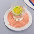 Detail eines runden Untersetzers aus Baumwollseil mit orange-weißem Spiralwebmuster - S / Orange