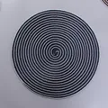 Detailed top view of a round blue and white woven placemat with a spiral texture - Sapphire Blue