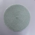 Detailed top view of round woven green and white spiral heat-resistant placemat - Green