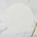 Detail of round white hand-woven ramie placemat with spiral texture on marble background - Solid White