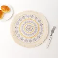 Detailed top view of round woven mandala placemat with fringe and sun pattern motif - Creative Pattern 12