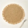 Macro shot of circular woven paper placemat with delicate fringe trim in boho style - 38cm / Beige Coffee