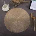 Detailed close-up of a round gold PVC placemat with elegant hollow woven feather texture - Alice (Gold)