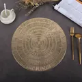 Close-up of a round gold hollow placemat with intricate radial patterns on a dark table - Stump (Gold)