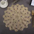 Detail of round hollow gold PVC placemat with woven geometric wave patterns and metallic finish - Vines (Gold)