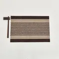 Dettaglio della tovaglietta intrecciata geometrica con trama in fibra marrone e beige - Marrone+Caffè