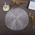 Close-up of silver round hollow placemat with sunburst design on dark tabletop - Fireworks (Silver)