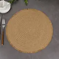 Top view of round woven placemat with delicate fringe trim on dark stone background - 38cm / Brown