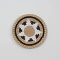 Macro shot of hand-woven round wall decor featuring geometric wave patterns in natural fibers - A9