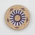 Macro detail of handwoven circular wall decor featuring purple and white spiral patterns - A5