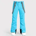 Waterproof blue ski bib pants featuring stylish black and white checkered suspenders - XS / Bottoms / Bright Blue