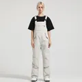 Women's off-white waterproof ski bib pants with adjustable straps and front pocket - XS / Bottoms / Off White