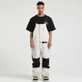 Waterproof white and black bib ski pants for men featuring adjustable straps and pockets - S / Off White