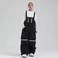 Women's professional black ski bib pants with adjustable straps and white zipper pockets - XS / Black