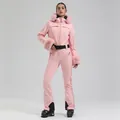 Pink one-piece women's ski suit with fur-trimmed hood and adjustable waist belt - XS / Pink