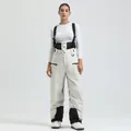 Beige insulated bib ski pants with adjustable black straps and white thermal base layer - Beige - Women