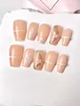 Detail of handmade nude press-on nails with 3D pearls, white floral art, and gold glitter - XS / 10 Pieces / Nude Pink