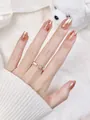 Nahaufnahme eines goldenen m-förmigen Rings mit Strass und weißer Emaille am Finger - XS / Liebeskummer (L10)