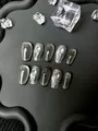 Macro di unghie finte cat eye grigio scuro con strass 3D su vassoio nero opaco - Stile Coffin Corto California Diary / XS