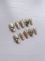 Detail of handmade press-on nails with champagne glitter and large luxury rhinestones - XS / Autumn Light Shadow - Short Coffin