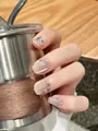Nahaufnahme handgefertigter Cat-Eye Kunstnägel mit Silberglitzer und Strasssteinen - XS / Maiglöckchen Katzenauge Kurz Quadratischer Stil