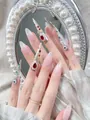 Detailed shot of handmade press-on nails with red teardrop gems and vintage pearls - XS / Palace Red Rhinestone Pearl Style