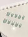 Detailed view of handmade mint green cat-eye press-on nails with silver glitter gradient - XS / Mint Green Cat Eye