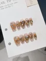 Dettagli di unghie finte fatte a mano con strass a cuore e gemme color champagne - XS