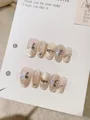 Nahaufnahme handgefertigter Kunstnägel mit 3D-Schmetterlingen und goldenem Katzenauge - XS