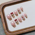 Detail of handmade press-on nails with pink gradient, gold glitter, and 3D lion dance decor - XS / Short Trapezoid