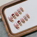 Detail of pink gradient press-on nails featuring red bows and lion dance motifs - XS / Short Oval Shape